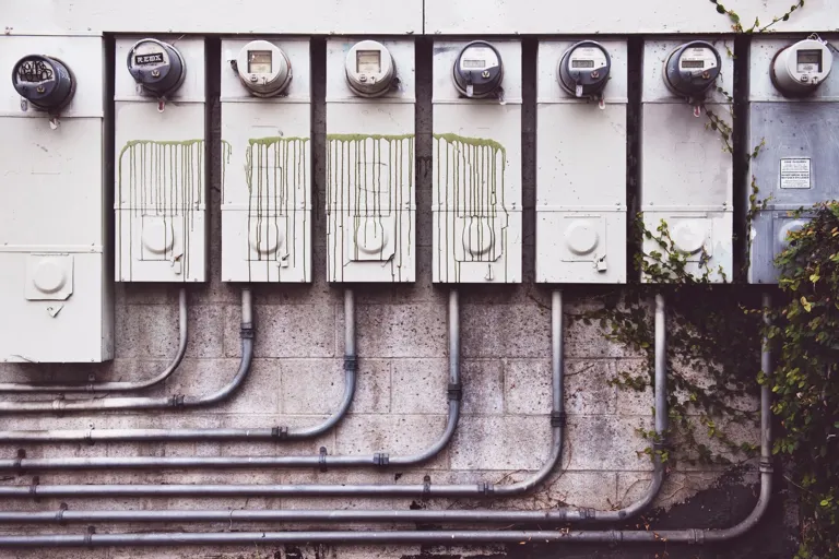 Rząd liczników energii elektrycznej na ścianie budynku