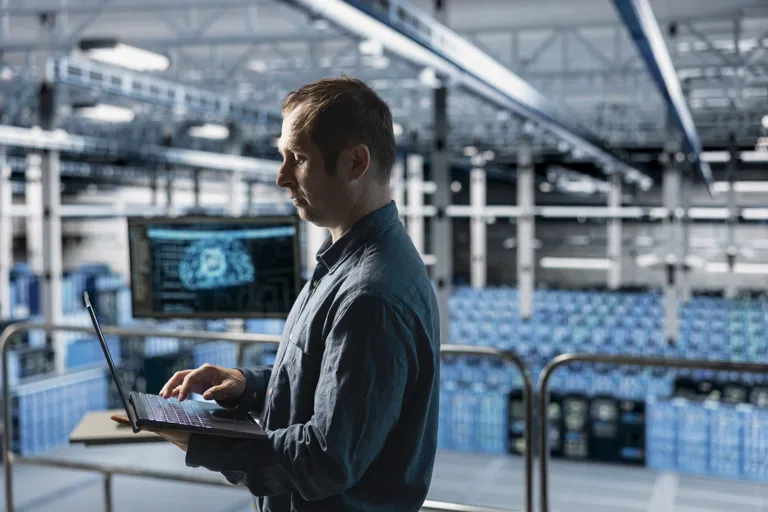 Specjalista IT pracuje na laptopie w centrum danych