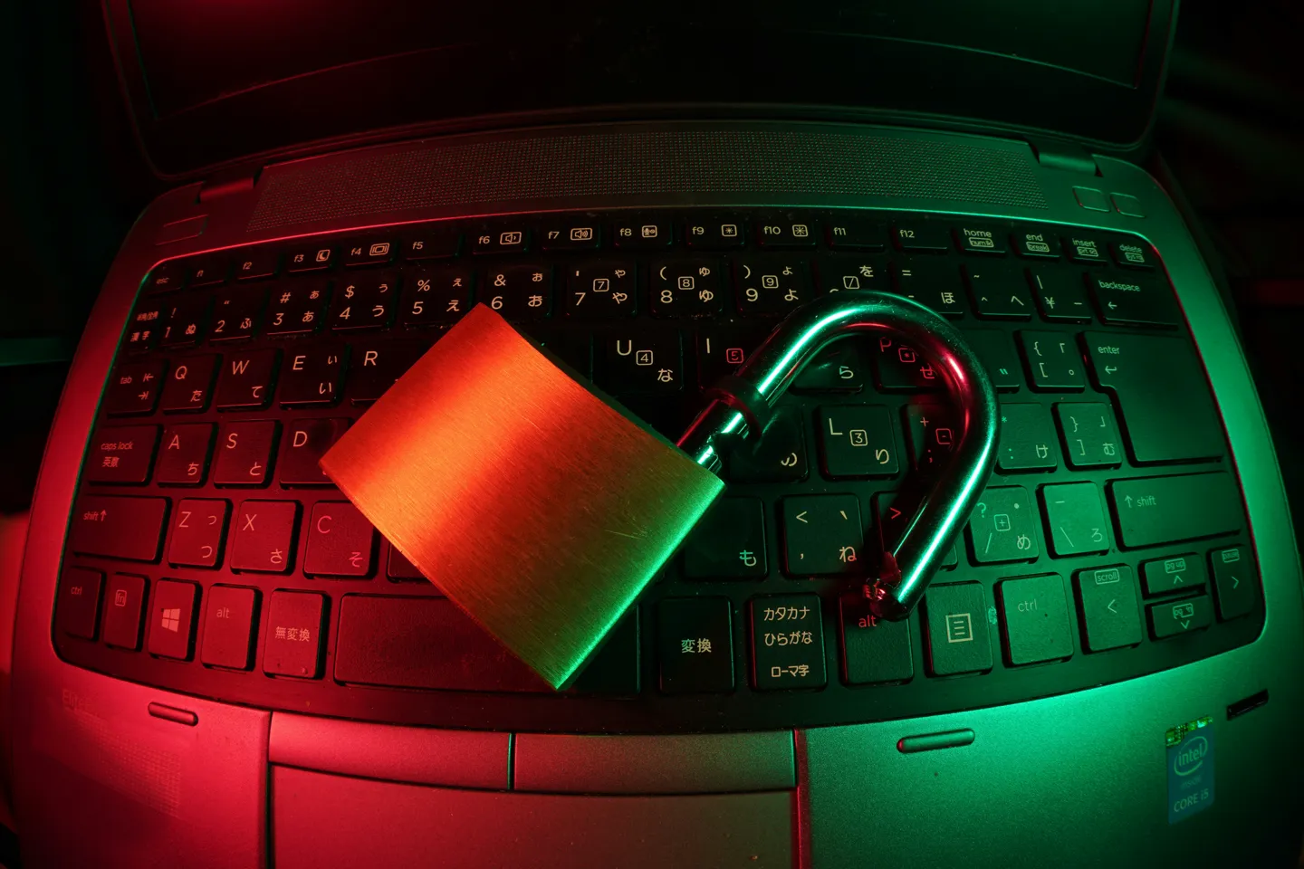Na laptopie leży otwarta kłódka symbolizująca wyciek danych i problem z bezpieczeństwem. 