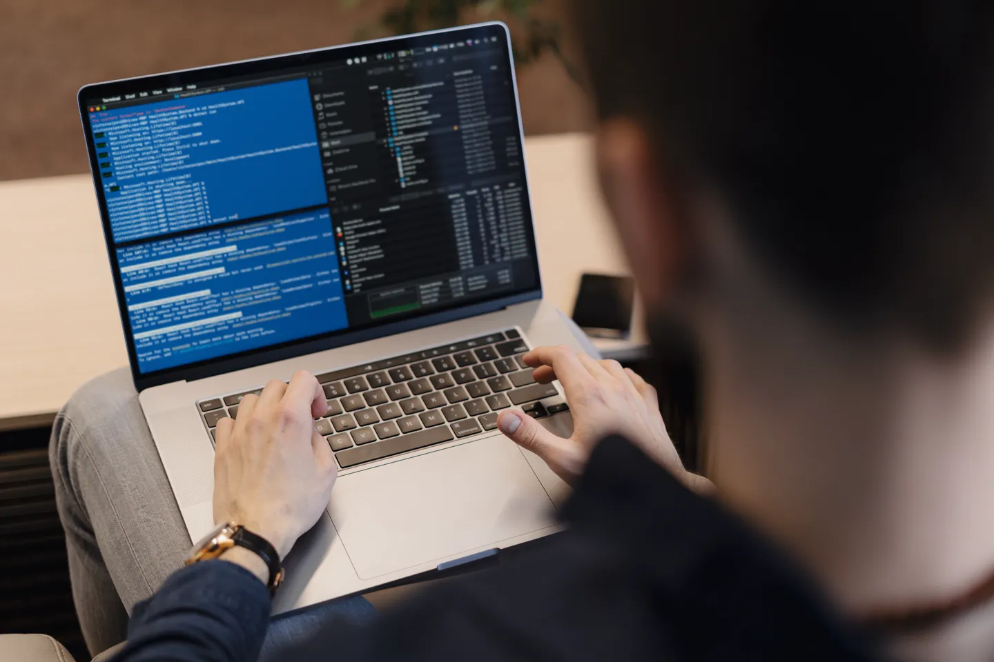 Programista piszący kod na laptopie, zbliżenie na ekran z kodem