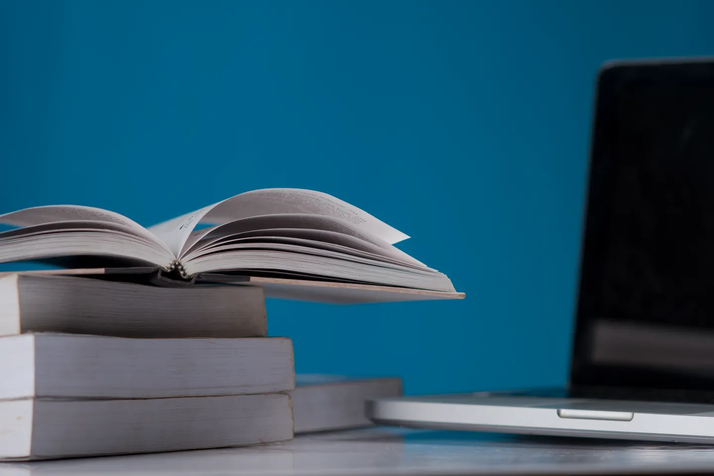 Laptop i książki w bibliotece, symbol firmowej bazy wiedzy