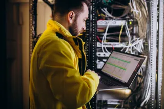 Administrator IT analizuje działanie programu przy komputerze