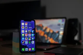 Telefon z wieloma powiadomieniami stojący na biurku w przygaszonym świetle