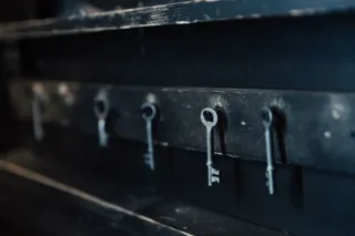 Stare klucze wiszące w rzędzie na haczykach czarnej listwy