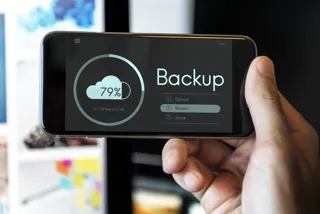 Smartfon z ekranem pokazującym przesyłanie kopii danych do chmury