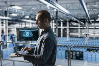 Specjalista IT pracuje na laptopie w centrum danych